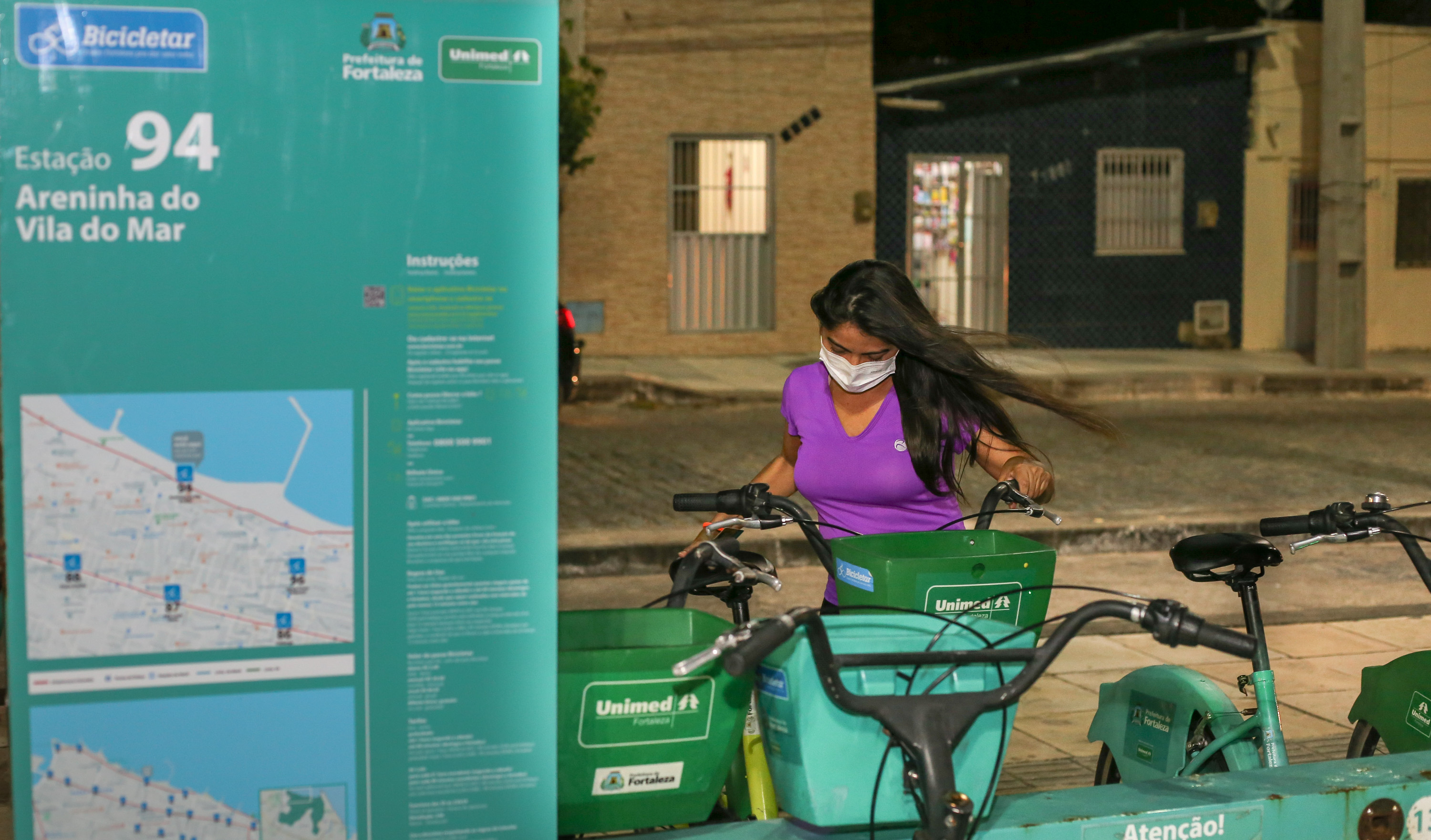 mulher retirando bicicleta de uma estação do Bicicletar